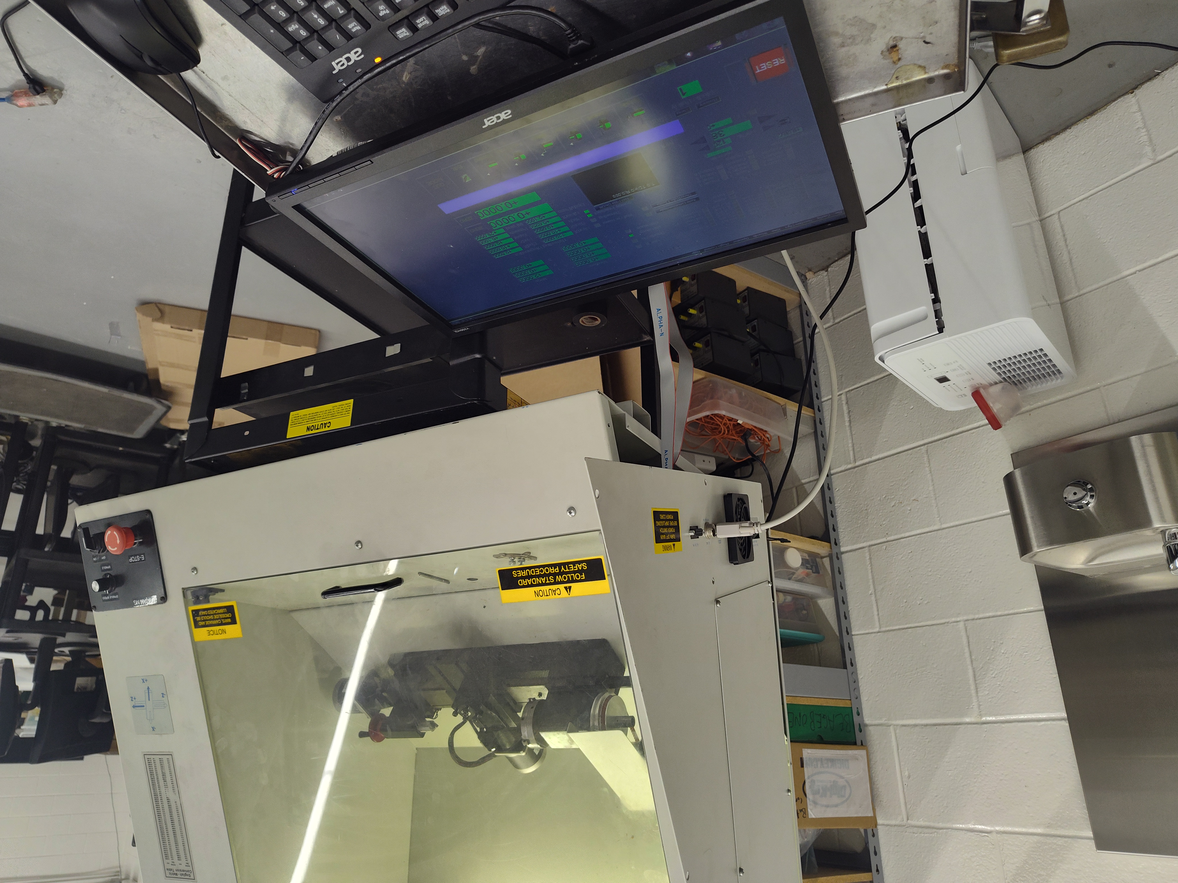 A CNC lathe connected to a computer displaying the LinuxCNC machine-control interface.